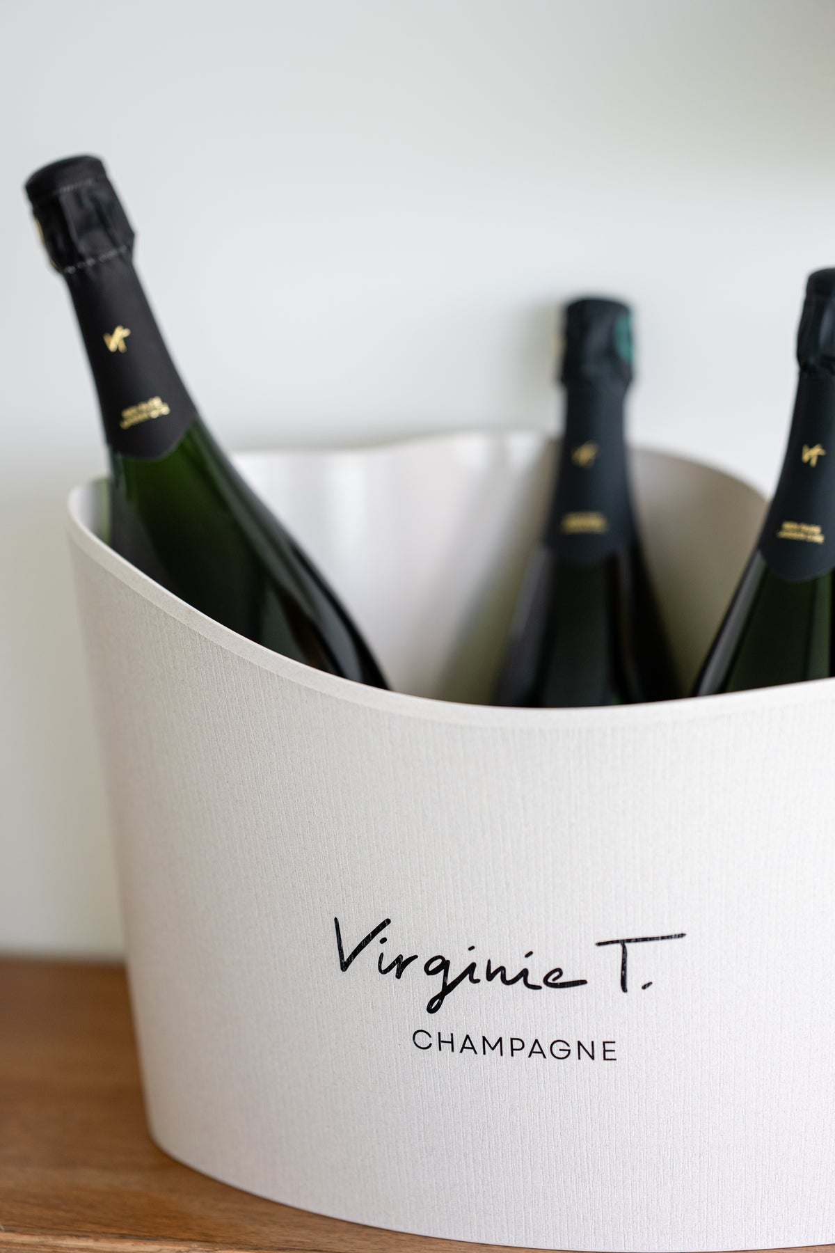Cuvées Virginie T. rafraîchies dans un seau à champagne blanc siglé du logo Virginie T.